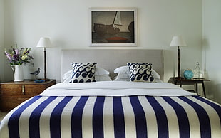 gray leather bed frame with white-and-blue stripe bedspread set